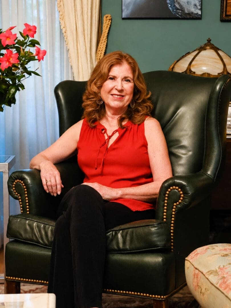 Woman sitting on a black leather couch